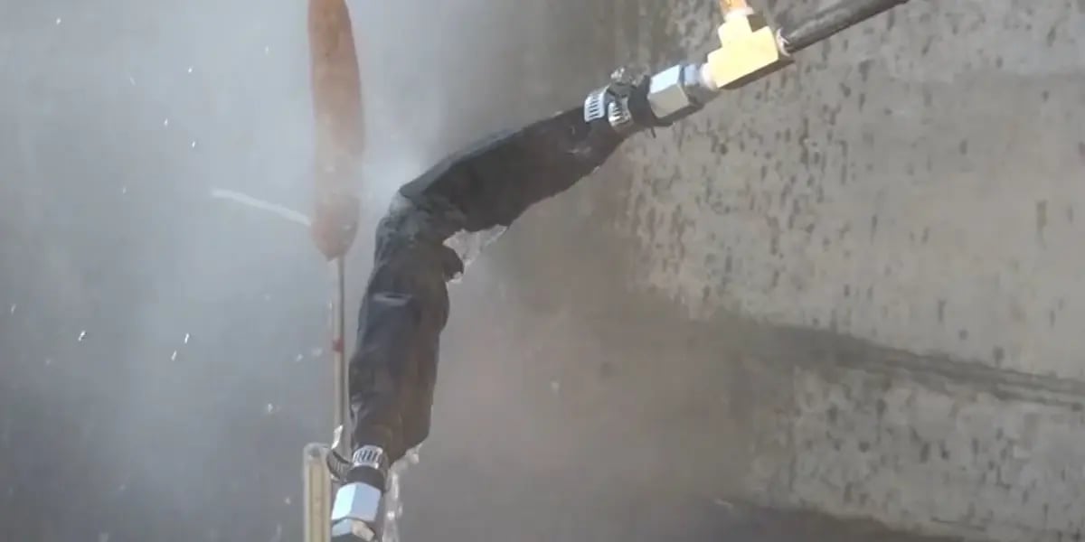 A high-pressure hydraulic hose with minimal fluid leakage due to a Python protective sleeve containing the damage.