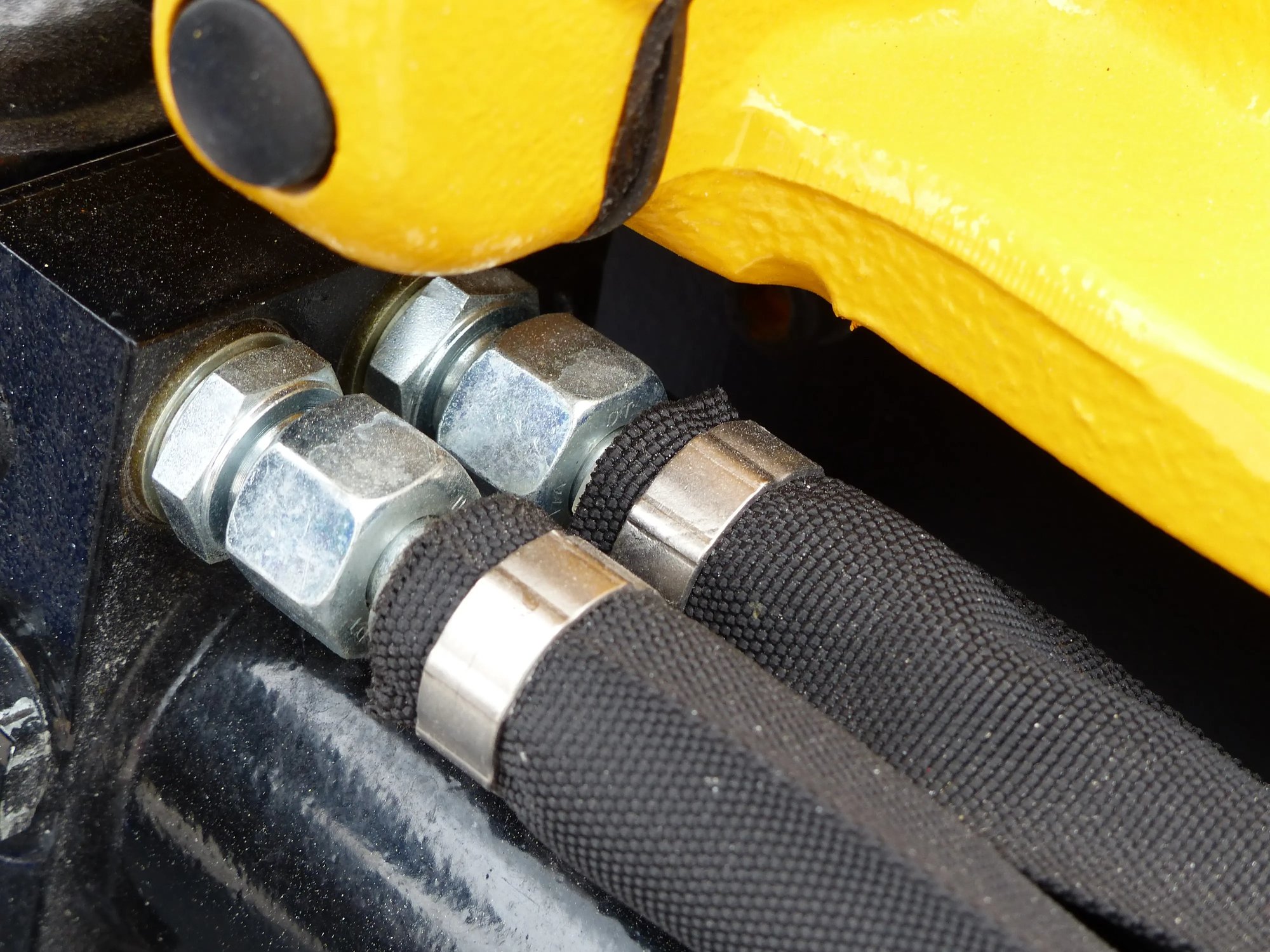 Hydraulic hoses with hose sleeves and band clamps for operator safety